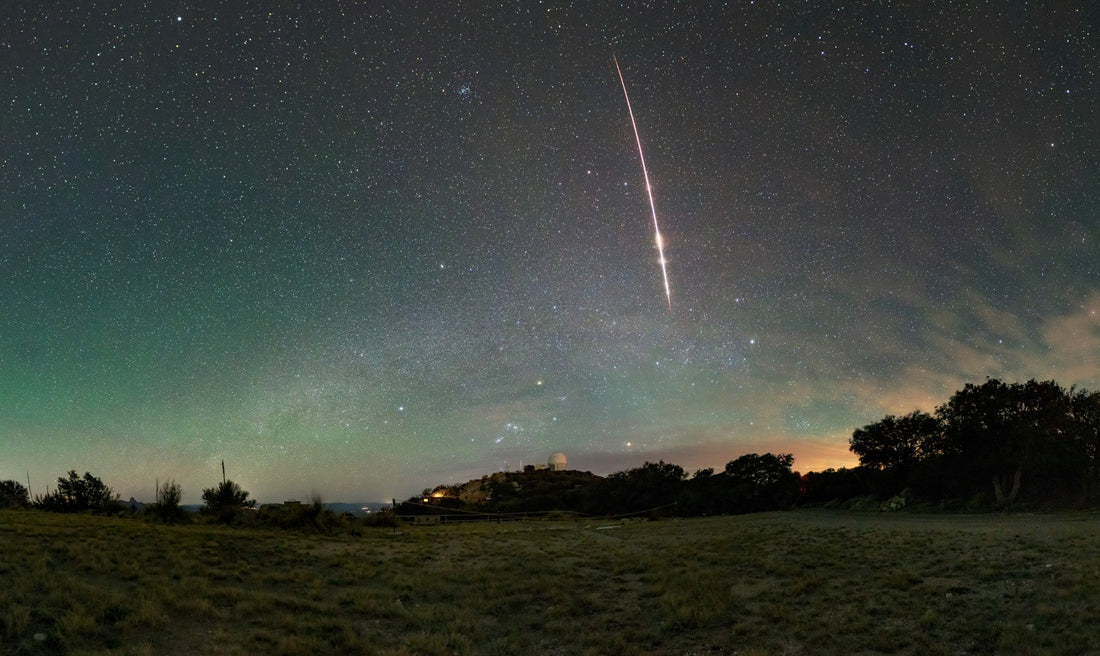A bright fireball meteor streaks across the predawn sky above Kitt Peak National Observatory in Arizona